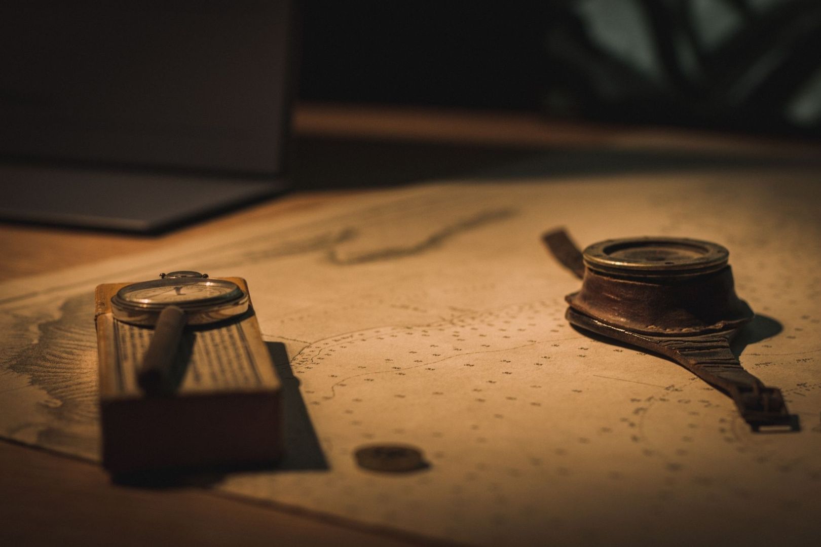 Vintage compass and nautical chart tools resting on a wooden table